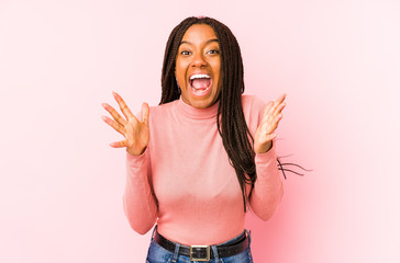 Young african american woman isolated on a pink background celebrating a victory or success, he is...