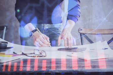 Multi exposure of man standing and planing investment with stock market forex chart.