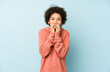 African american little boy isolated laughing about something, covering mouth with hands.