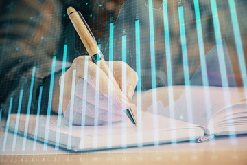 Double exposure of woman's hands making notes with forex graph hologram. Concept technical analysis.