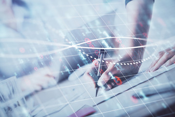 A woman hands writing information about stock market in notepad. Forex chart holograms in front. Concept of research. Double exposure