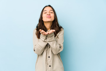 Young mixed race hispanic woman isolated folding lips and holding palms to send air kiss.