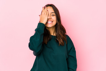 Young mixed race hispanic woman isolated having fun covering half of face with palm.