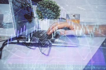 Multi exposure of graph with man typing on computer in office on background. Concept of hard work. Closeup.