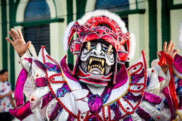 closeup man in motley mask and costume poses for photo at dominican carnival