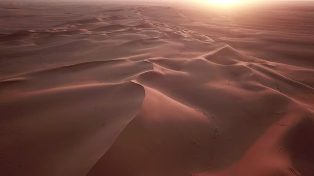 Flying over sand dunes at sunset in beautiful desert landscape in Saudi Arabia, natural scenery in Middle East