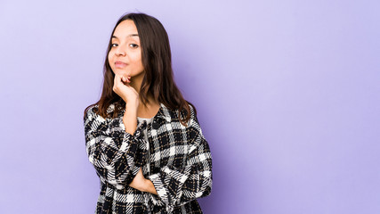 Young mixed race hispanic woman isolated suspicious, uncertain, examining you.