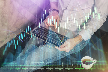 Forex graph with businessman working on computer in office on background. Concept of analysis. Double exposure.