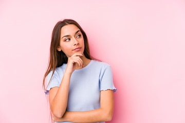 Young caucasian woman wearing a ski clothes isolated looking sideways with doubtful and skeptical expression.