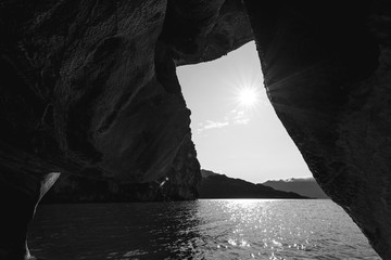 Capilla de marmol desde el interior y el sol asomandose en una esquina en color blanco y negro