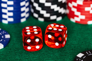 a boxcar sixes roll on a green felt craps table with stacks of Red, Black and Blue betting chips in the background.