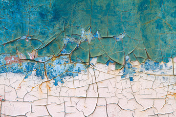 Old paint cracks on steel wall texture background. Cracked wall with old layers of paint.
