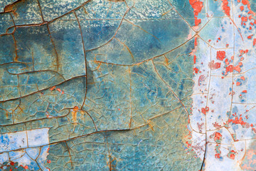 Old paint cracks on steel wall texture background. Cracked wall with old layers of paint.