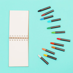 Oil pastel crayons and sketch pad for drawing. Workplace of artist. Social media and creativity background with copy space.