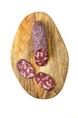 smoked salami sausage and slice of sausage on wooden board on a white background. Vertical photo. Copy space. Flat lay. Top view.