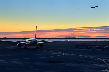 New York airport at dawn with jets taxiing and taking off