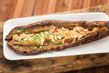 The newly baked eggplant is placed on the wood background
