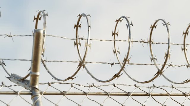 Endless view at the top of prison or airport fence on blue sky background. 4k HD