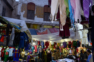 Fototapeta na wymiar Crowded labyrinth and clothing shopkeepers in the old Medina of Casablanca