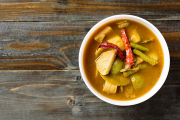 Southern Thai food (Kaeng Tai Pla ), fish organs sour soup in a bowl on wooden background, Top view