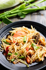 Thai food (Som Tum), spicy green papaya salad eating with fresh vegetables