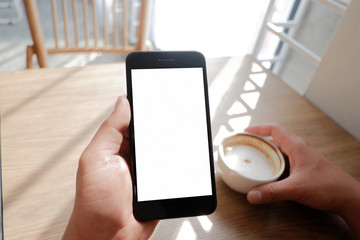 Mockup picture of business man’s hands holding smart phone with white blank screen in modern place