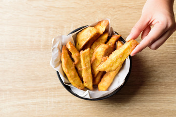 Deep-fried sweet potato in a bowl eating by hand, Delicious homemade snack