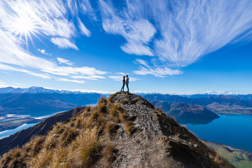 Fototapeta na wymiar Young Asian couple holding hands kissing at Roys Peak Lake Wanaka New Zealand