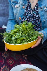 Fresh green herbs big pile, heap or bunch on plate in woman hands. Raw, vegan, vegetarian healthy dieting concept.