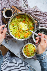 Indian basmati biryani pilaf colorful rice in woman hands with vegetables. Vegan, vegetarian healthy food.