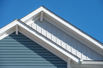 Double gable, with white decorative corbel, bracket, brace on a triangle gable roof, white soffit...