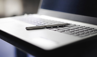 laptop and pen on computer