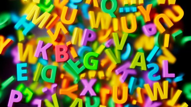 Many colorful letters falling down into a pile on transparent glass. 4K HD