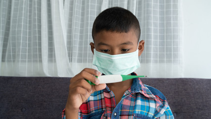Cute little asian boy sick and wearing mask
