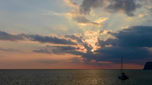 Time lapse Light of sun pass through clouds with yacht in sea moving fast at koh mook, Trang, Thailand