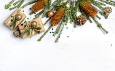 Beautiful Australian inspired Christmas composition. Native Banksia's with elegantly wrapped gifts, gold ribbon, decoration, pine cones and glitter one a white wooden background.