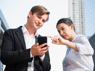 Portrait of businessman and woman looking at phone