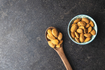 Dried almond nuts in spoon and bowl.