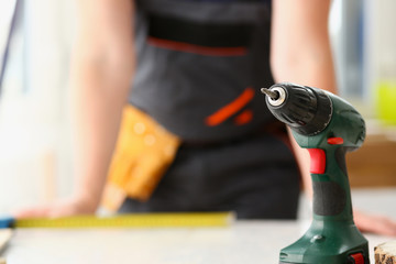 Arms of worker using electric drill closeup. Manual job, DIY inspiration, improvement job, fix shop, yellow helmet, joinery startup idea, industrial education, profession career concept