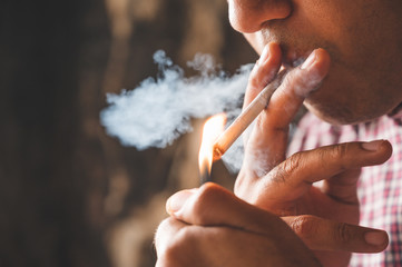 Close up young man smoking a cigarette.