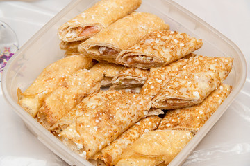 Stuffed pancakes in a food container. Delicious pancake breakfast