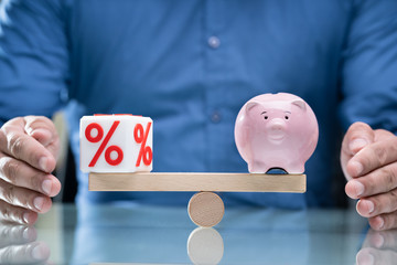 Hand Protecting Balance Between Percentage And Piggybank