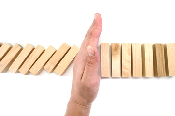 Risk and Strategy in Business, Image of hand stopping falling collapse wooden block dominoes effect from continuous toppled block, prevention and development to stability.