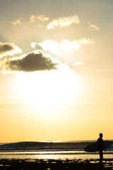 Fototapeta na wymiar Surfer enjoying the sunset after a surf session