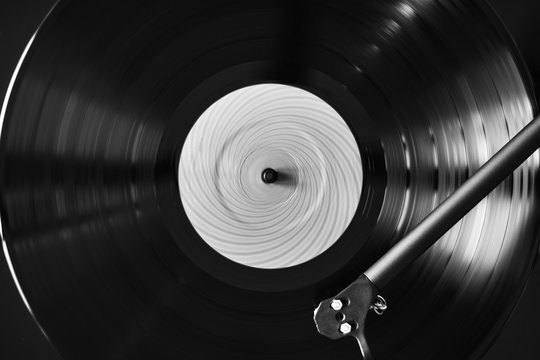 Black and white photo of turntable playing vinyl record	