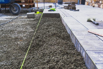 Ausschnitt einer Baustelle. Der Fokus liegt auf dem beton im Vordergrund. Der Hintergrund liegt...