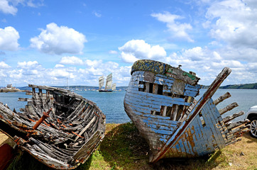 Boat cimetry with big beautiful sailing boat at the background. Brittany, France