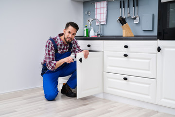 Man In Overall Repairing Cabinet