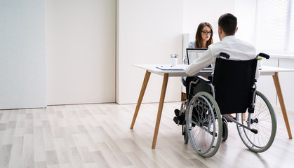 Disabled Businesswoman Sitting With Her Partner In Office