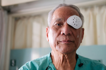 patient covering eye with protective shield after eyes cataract surgery in hospital - obrazy, fototapety, plakaty